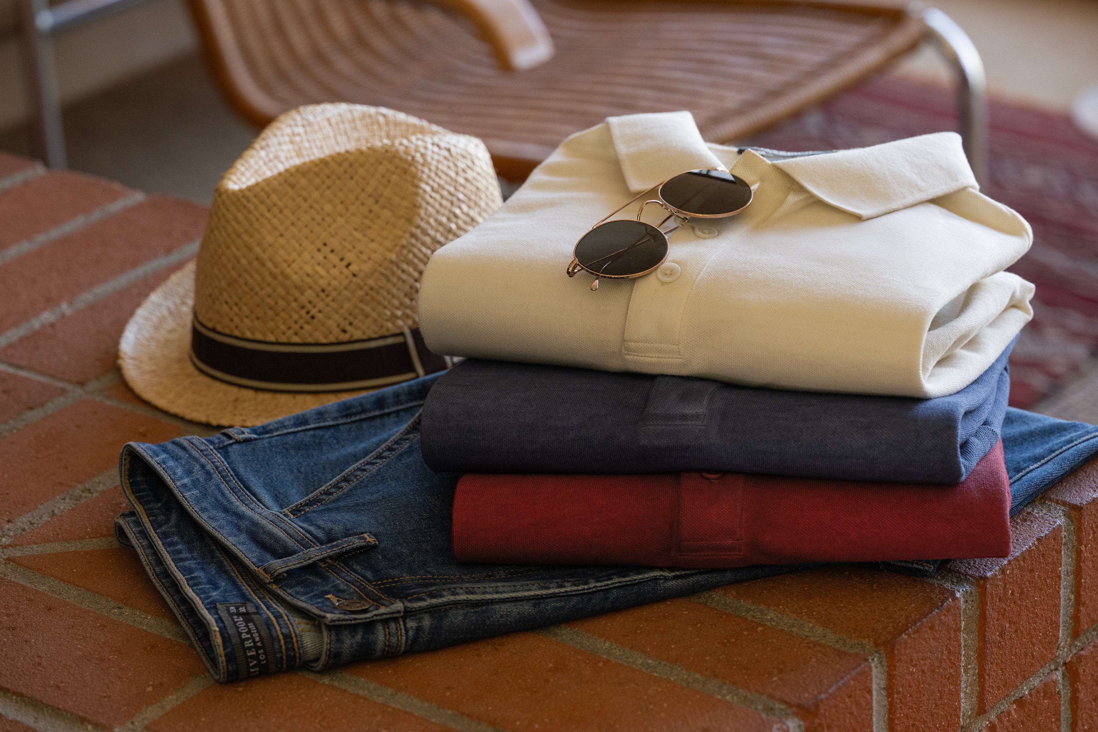 Liverpool cream, navy and red polos folded over indigo jeans, showing collars, plackets and denim topstitching