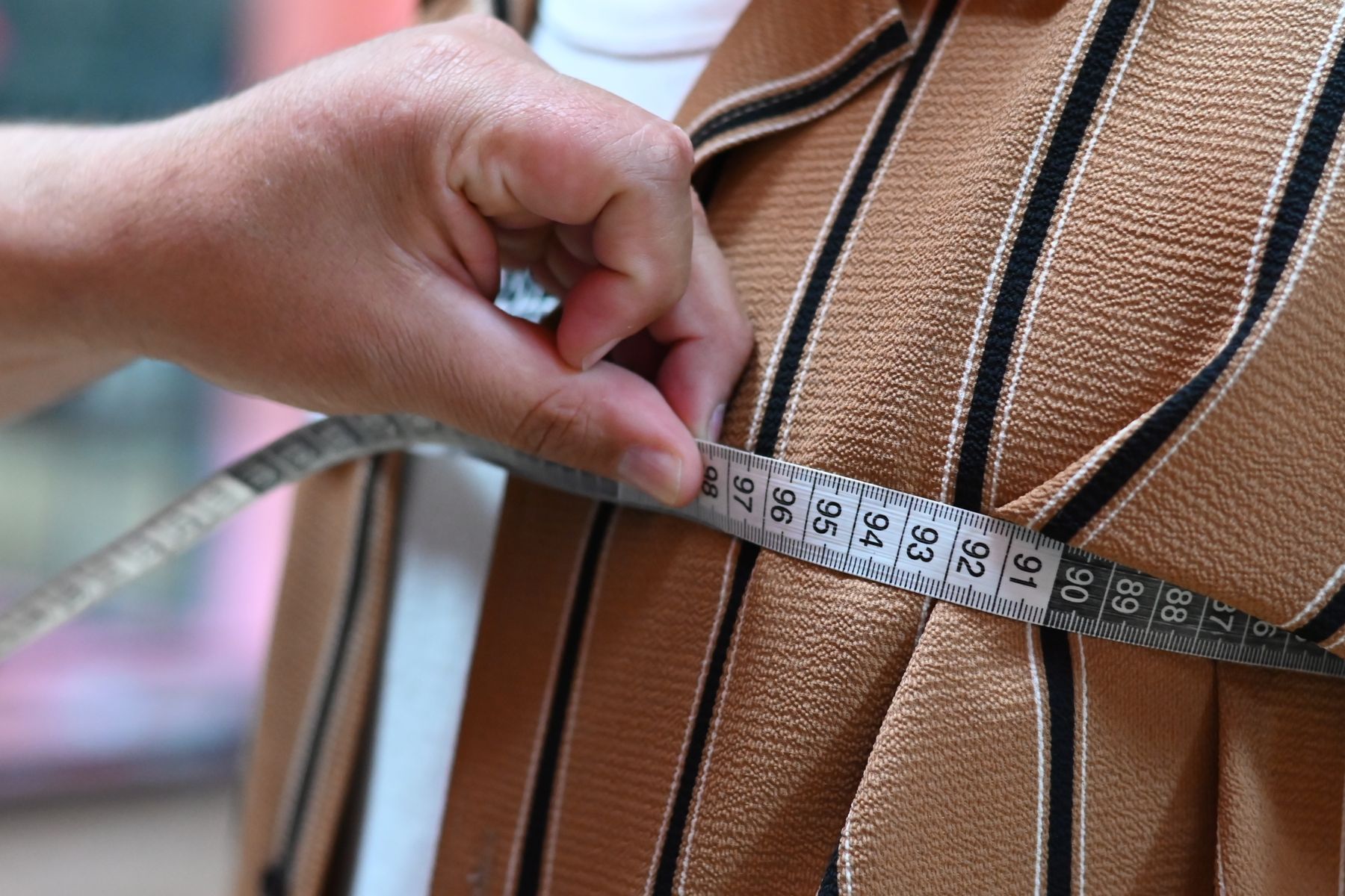 A tape measure checking a striped garment